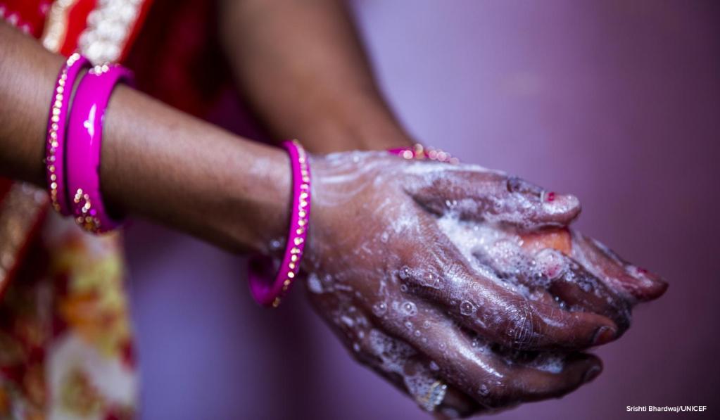 A woman washing her hands with soap.