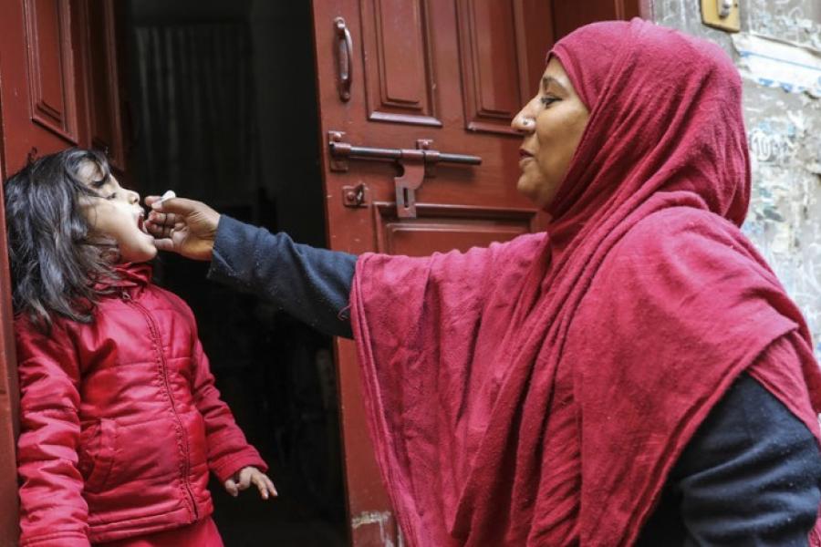 A health worker vaccinates a 4-year-old girl against polio at the door of her house in Bhatti gate area of Lahore Punjab Province, Pakistan.